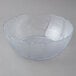 A Carlisle clear polycarbonate bowl with a scalloped edge.