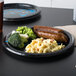 A Creative Converting Carolina Panthers paper dinner plate with sausage, broccoli and macaroni on it.
