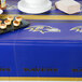 A table with a Baltimore Ravens table cover, plates, and napkins on it.