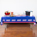 A table with a New York Giants tablecloth and food on it.
