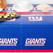 A table with a New York Giants tablecloth on it.