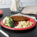 A Kansas City Chiefs paper dinner plate with meat and broccoli on a table