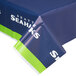 A blue and green Seattle Seahawks table cover with white writing on a table.