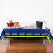 A table with a blue Seattle Seahawks table cover with food and drinks on it.