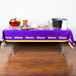 A table with a Creative Converting Minnesota Vikings plastic table cover with food on it.