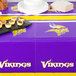 A table set with a Minnesota Vikings table cover and white plates.