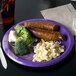 A white paper plate with a purple Minnesota Vikings logo filled with meat, broccoli, and macaroni.