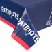 A New England Patriots table with a blue and red plastic table cover.