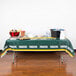 A Green Bay Packers plastic table cover on a table with food.