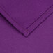 A close up of a purple cloth with a red stitch.