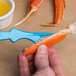 A person using a Choice Light Blue Seafood Sheller to peel a crab leg.