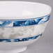 A close up of a blue and white Thunder Group Blue Dragon melamine rice bowl.