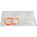 A pair of orange rubber bands on a silver Menu Solutions aluminum board.