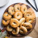 An American Metalcraft faux acacia melamine serving board with bagels on it.