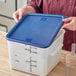 A person opening a Choice blue polypropylene food storage container lid.