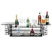 A Rosseto black tempered glass narrow riser shelf holding a bottle of alcohol and glasses.