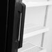 The inside of a black refrigerator with Avantco pilasters on the shelves.