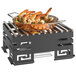 A Rosseto black matte steel butane burner stand with a grill top holding a large pan of shrimp.
