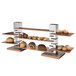 A Rosseto natural walnut square riser shelf displaying pastries and muffins.