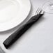 A fork and knife wrapped in a Hoffmaster black linen-feel napkin.