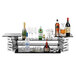 A Rosseto stainless steel multi-level riser on a table with bottles and glasses on each shelf.