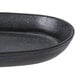 A black oval cast iron fajita skillet with a black rim.