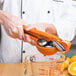 A person using a Chef'n orange juicer to squeeze orange juice.