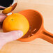 A person using a Chef'n FreshForce orange juicer to squeeze an orange.