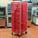 A red Curtron bun pan rack cover in a kitchen.