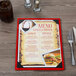 A Menu Solutions wood menu board on a table with a close up of a menu with a picture of food.
