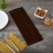 A customizable walnut wood menu clip board on a table with a bowl of nuts and a fork.