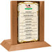 A Menu Solutions country oak wood menu holder with a 5" x 7" insert slot on a table.