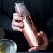 A man using a Barfly copper cocktail shaker with ice.