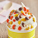 A cup of ice cream with Chopped REESE'S PIECES® on top.
