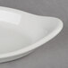 A Hall China white oval Au Gratin dish on a gray surface.