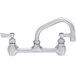 A Fisher stainless steel wall mount faucet with lever handles and a swing nozzle.