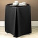A black table with a black Wyndham tray stand cover on it.