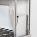 An Avantco stainless steel double deck overshelf over a counter.