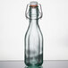 An Arcoroc clear glass swing top bottle with a white cap.