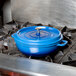 A cobalt blue Get Heiss brazier with lid on a stove.