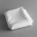 A folded white cloth on a gray surface.