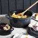 A gray GET Heiss Dutch oven with food in it and a wooden spoon.