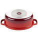 A red and white enamel oval dutch oven with a lid.