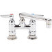 A chrome T&S deck-mounted faucet with two lever handles and a swivel nozzle.