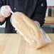 A person holding a bag of bread in a LK Packaging plastic food bag.