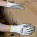A person wearing Cordova Rival cut resistant gloves holding a box.