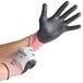 A person wearing Cordova cut resistant gloves with black foam nitrile palms.