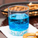 A Libbey customizable rocks glass with blue liquid and ice next to pretzels.