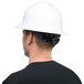 A man wearing a Cordova Duo Safety white full-brim hard hat with black shirt.
