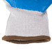 A close up of a blue and white knitted glove with brown trim.
